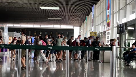 Catania, Italy, July 2021: People in line waiting for ticket control and boarding in the aircraft at the gate of Catania Fontanarossa airport, Italy