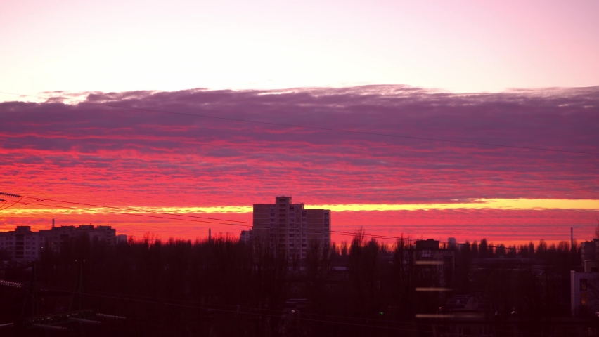 Red sunset over the city. Beautiful sky. Dramatic crimson clouds. Red thundercloud over Kyiv, Ukraine, Europe. Landscape from the window. Evening and twilight. Horizon strip. The sun goes down Sunrise