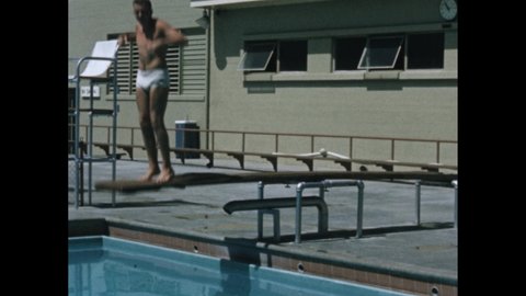 1950s: Hand holds shooting slate. Pool. Man walks to end of diving board and bounces. Man dives into pool. Women sunbathe.