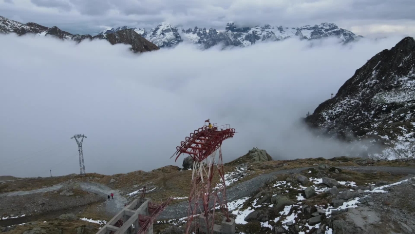 Man climbs around on an old mountain lift system in the mountains. Old mast of a gondola 