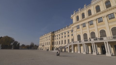 VIENNA AUSTRIA - NOV 12. 2019 Shot of Schönbrunn Palace  Schonbrunn Palace, moving towards palace baroque garden of Schönbrunn Palace, blue sky, people walking along, no sound
