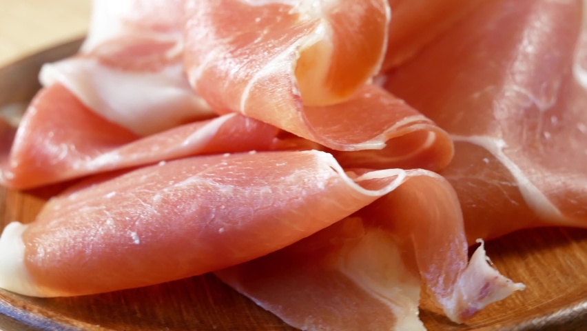 Slices Of  tasty  Jamon  or prosciutto On The Wooden Background Royalty-Free Stock Footage #1082916004