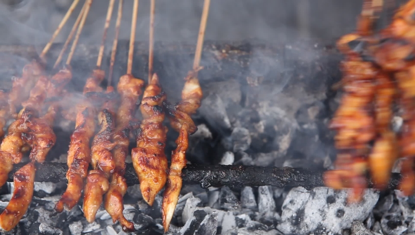 Satay is the English spelling, and also the modern Malaysian spelling, though it's sate in Indonesia. It's thought the dish originated there, in Java, as a local take on the skewered kebab introduced  Royalty-Free Stock Footage #1082916547