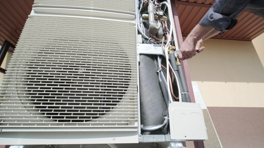 HVAC technician installs heating, ventilation and air conditioning systems. Heat pump | Shutterstock HD Video #1082917624