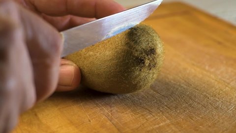 Cutting delicious kiwi slices on a wooden board. Close up. Kiwi fruit. Vitamin.
