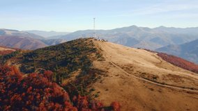 A drone flies next to a telecommunications antenna on top of a mountain. Cell site of telephone tower with 5G base station transceiver. Cinematic aerial shot. Beauty of earth. Filmed in 4k video.