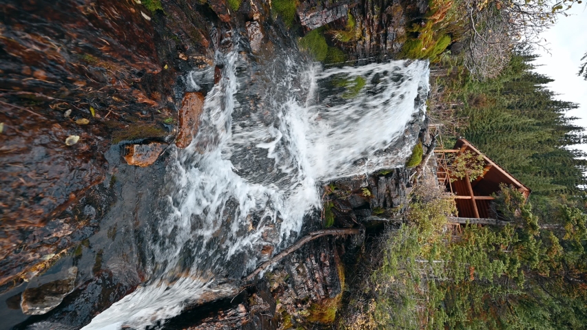 Waterfall flowing with wooden tea house in autumn forest on Lake Agnes at Banff national park, Canada