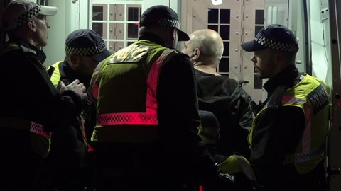 London , United Kingdom (UK) - 11 05 2021: Metropolitan riot police detain an arrested Million Mask March protester next to a police van