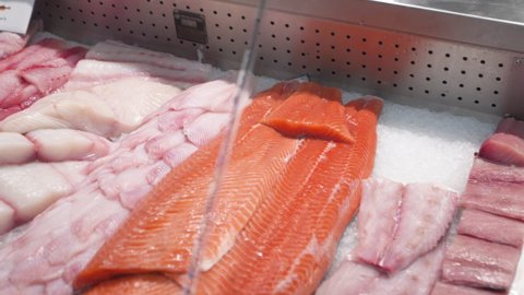 Various cuts of seafood in fish market display case, slider HD