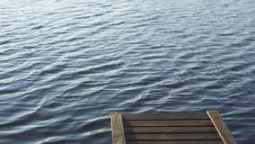 4k stock video footage of wooden pier isolated on calm peaceful blue river water background