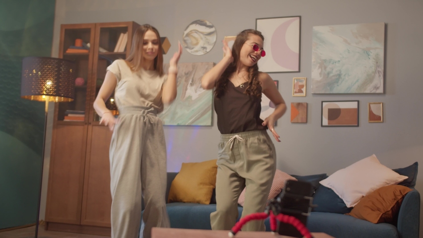 Teenagers womans shooting together dancing at home while making video for social media, stories hip hop popular trandy dance, students at home make content for network. | Shutterstock HD Video #1082941834