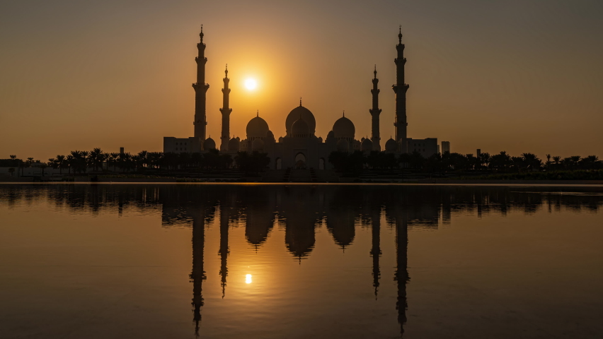 Sheikh Zayed Grand Mosque in Abu Dhabi in UAE- Time Lapse of day to night transition seen from Wahat Al Karama with the mosque reflected in pond | Shutterstock HD Video #1082948602
