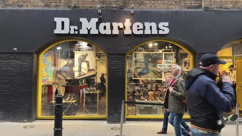 London UK  - 18th November 2021 - Dr Martens shop exterior in Covent Garden, with shoppers walking by in slow motion. Doc Martens is a is a British footwear and clothing brand