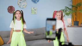 internet challenge, modern beautiful female teens with colored hairstyles together dancing when making popular video for social media during their holidays at home