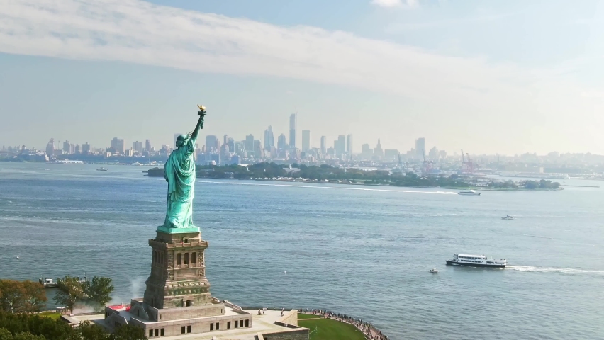 Aerial views of the Statue of Liberty. Colossal sculpture on Liberty island. Harbor in New York, in the United States. Travel destination and popular tourist city in America. Royalty-Free Stock Footage #1082965261