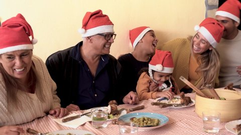 Cheerful latin family enjoy christmas dinner together at home 