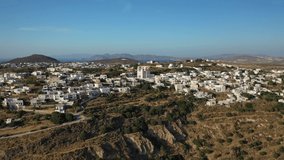 Aerial drone video of beautiful whitewashed village of Tripiti built uphill with great views to Aegean sea and main village or chora of Milos island, Cyclades, Greece