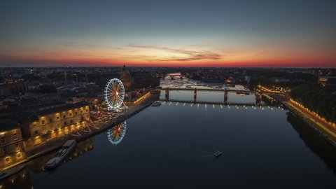 Establishing Aerial View Shot of Toulouse Fr, Haute-Garonne, France, sunset, evening, riverside and colorful ferris wheel