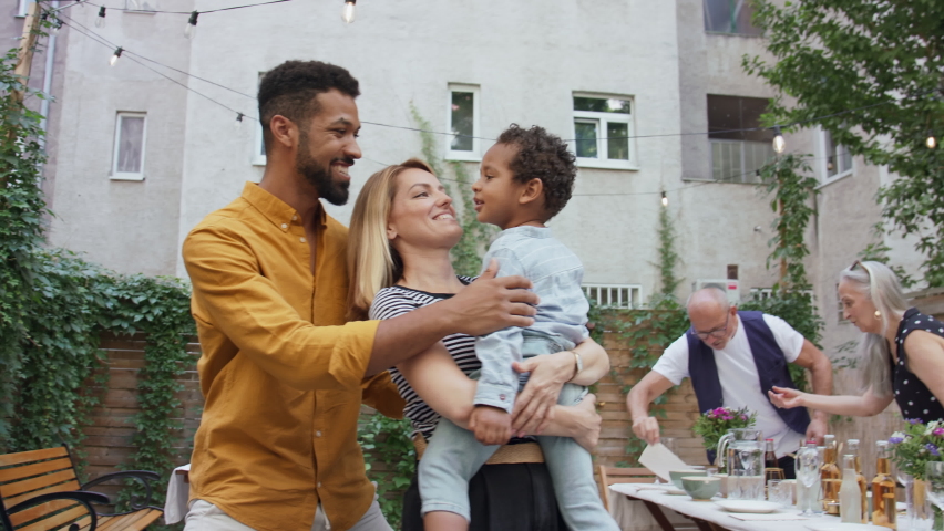 Happy biracial family with small son during family dinner with grandparents outdoors in garden. | Shutterstock HD Video #1082976952