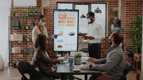 African american workmates presenting marketing strategy to colleagues, using tablet and monitor in startup office. People planning business growth and development during covid 19 pandemic. - Powered by Shutterstock - Get 15% off with code: PIKWIZARD15