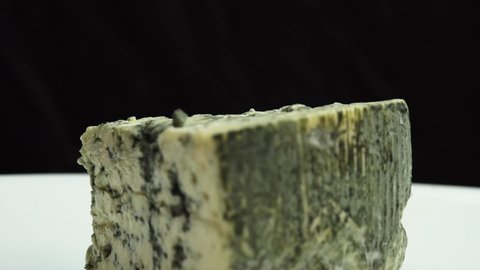 Texture of blue cheese. Blue noble blue cheese is spinning on a plate. Fragrant blue cheeses with noble mold