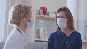 Caucasian woman and caucasian female doctor wearing face mask at home using swab test. Medicine, health and healthcare services during coronavirus covid 19 pandemic - Powered by Shutterstock - Get 15% off with code: PIKWIZARD15