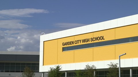 Garden City, Kansas - USA - September 1, 2017 - Establishing shot of a modern high school on a sunny daytime view with white clouds and a blue sky.  Tripod shot locked down with ProRes422 HQ codec.
