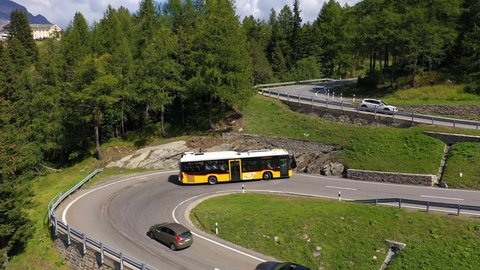 Maloja, Switzerland - September 05 2021: Aerial drone footage of a postal bus that drives up the Maloja pass in Canton Graubunden in the alps in Switzerland