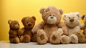 Group of cute brown teddy bears sit on yellow background, childrens toy - Powered by Shutterstock - Get 15% off with code: PIKWIZARD15