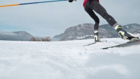 SLOW MOTION, LOW ANGLE, CLOSE UP, DOF: Athletic young woman trains skiing in wintry Bohinj. Professional skiing athlete pushes off her ski and poles while training in snowy mountains. - Powered by Shutterstock - Get 15% off with code: PIKWIZARD15
