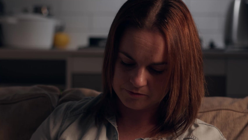 Depressed Woman Strokes Pet Dog on Couch in Empty House. Close Up