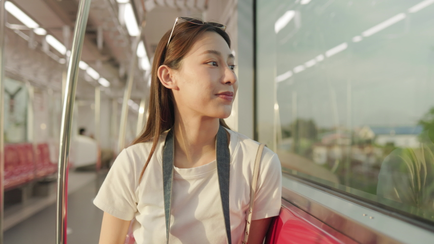 Young asian woman traveler with backpack in the railway, Backpack and hat at the train station with a traveler.Alone woman with maps and planning travel by train at train station.
 Royalty-Free Stock Footage #1083023857