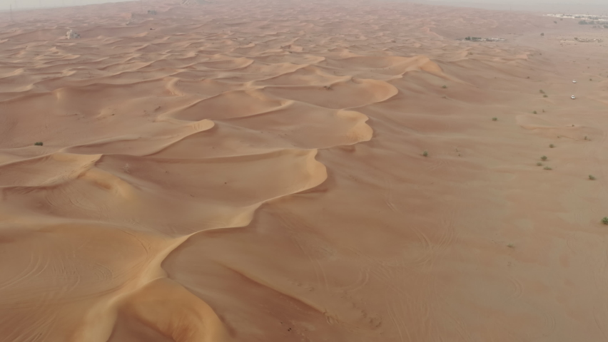 Aerial view of the desert in the UAE. Sand dunes in a beautiful landscape with desert nature on the Arabian Peninsula. Royalty-Free Stock Footage #1083029536