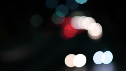 Vehicle traffic headlights driving on a road at night blurred bokeh abstract background