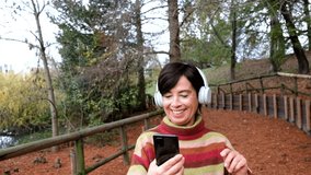 Senior woman dancing while listening a song with headphones 