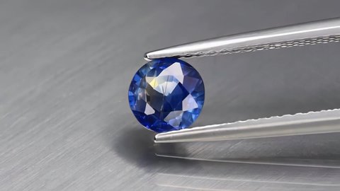 natural blue sapphire gemstone in the tweezers