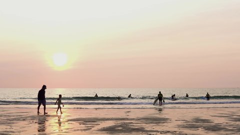 Biarritz , France - 11 10 2021: Surfer with Surfboards going to the Sea on Sandy Beach during Sunset