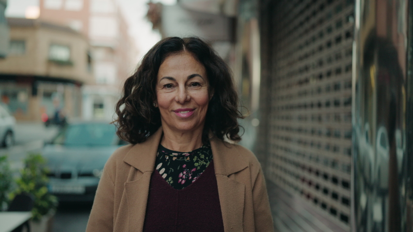 Middle age hispanic woman smiling confident walking at street