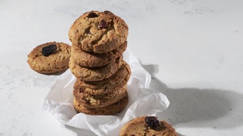 Stack of round oat biscuit cookies with raisins on white background, selective focus