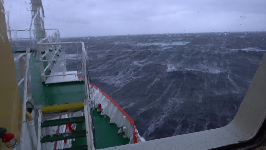 Ship in storm. A lot of splashes. View from bridge. Ship climb up wave. Strong pitching. High waves hit ship. White foam on water. Very strong storm. Bow breaks waves | Shutterstock HD Video #1083053806