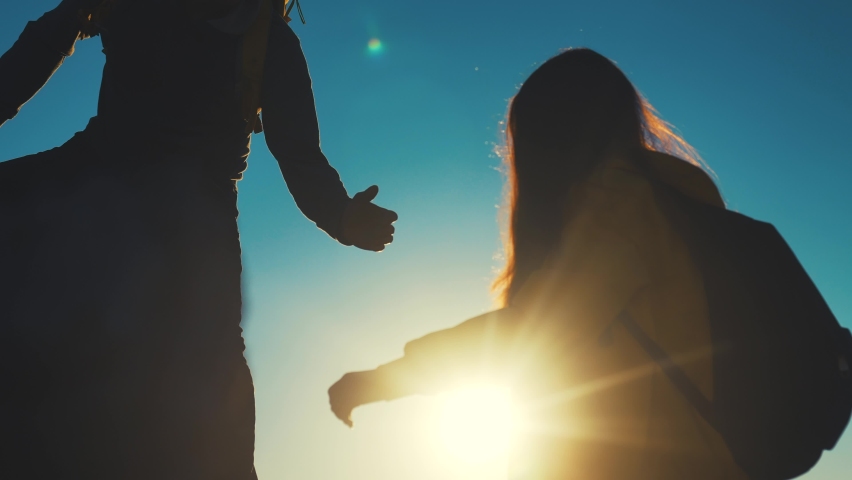 help team concept. couple team silhouette of two climber stretching a helping hand to a friend. business teamwork success sunlight concept. silhouette business travel tourists pull a helping hand Royalty-Free Stock Footage #1083056719