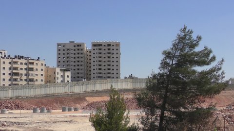 View to old airport in Jerusalem and new vacant Palestinian buildings near it behind the separation wall between Israel and the Palestinian Authority, pan