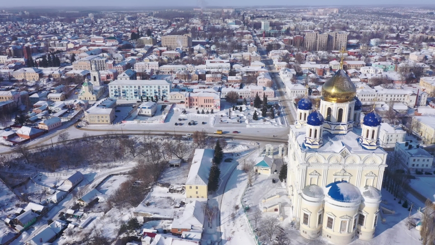 Aerial view of the Ascension Cathedral, located in the historical center of the city on the Red Square of Yelets, and the surrounding his residential areas in winter, Russia. Royalty-Free Stock Footage #1083067939