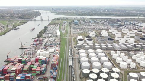 Container and silos in the Port of Rotterdam heavy industry and transportation along the Oude Maas Petroleum harbour aerial drone overview.