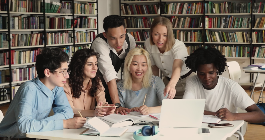 Group of students, high school pupils gather in college library, discuss topics, work together on creative task, prepare for university test or exams use laptop. Education, study, modern tech concept Royalty-Free Stock Footage #1083071689