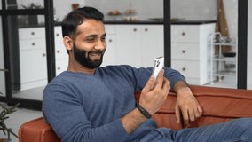 Happy young bearded Indian eastern man holding cellphone and making video call, Hispanic guy glad to see online interlocutor, using smartphone for virtual connection, talking online, viertual chatting