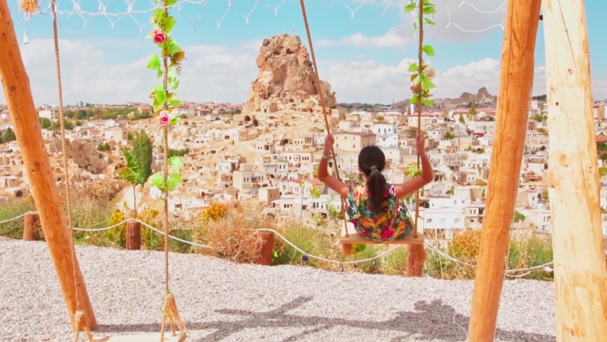dreamy caucasian girl on famous Cappadocia swings enjoy sunset in Turkey