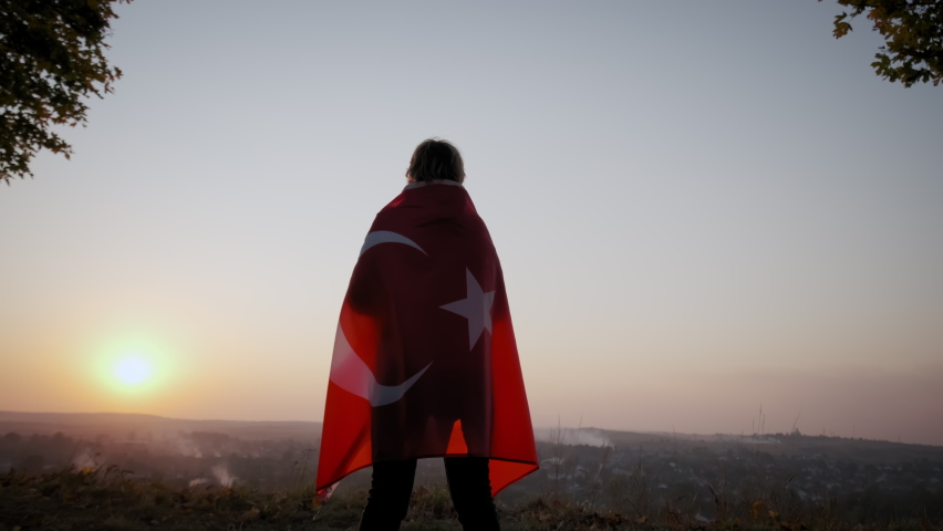 Back view of happy woman with turkish national flag standing outdoors at sunset. slow motion sgot Royalty-Free Stock Footage #1083091657