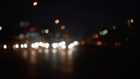 Beautiful blurring of the frame of the evening road with traffic jams and city lights. Bokeh car headlights, signage and street lights. Beautiful background with a pecherny atmosphere
