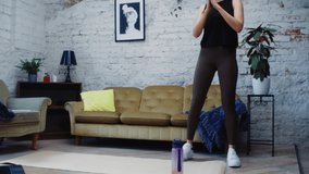 Isolated Young Caucasian Female Working Out In Her Living Room. Doing Lunges in Her At-Home Workout Routine That She Watches on Her Grey Laptop Device,  Industrial Studio Apartment In the Background.